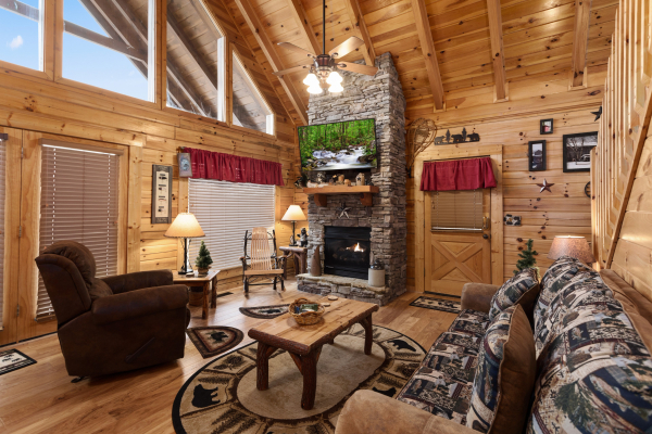 Living room with fireplace and TV at Bootlegger's Bounty, a 1-bedroom cabin rental located in Pigeon Forge