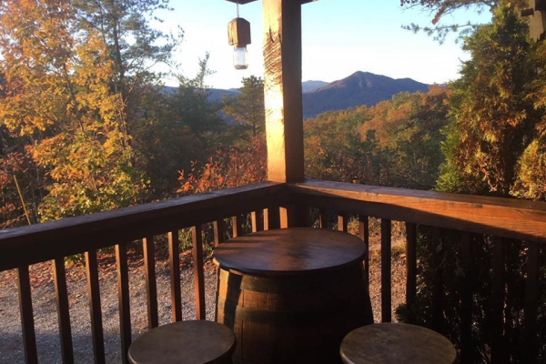 Table and stools on the deck at Bootlegger's Bounty, a 1-bedroom cabin rental located in Pigeon Forge