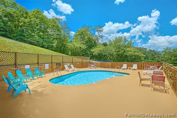 Guests at Howlin' in the Smokies, a 2 bedroom cabin rental located in Pigeon Forge can access the pool with deck lounge chairs at Starr Crest Resort
