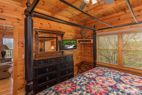 Bedroom with a canopy bed, dresser, and TV at Howlin' in the Smokies, a 2 bedroom cabin rental located in Pigeon Forge