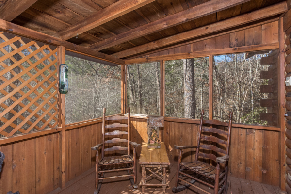 Rocking chairs on a screened in porch at Snuggle Inn, a 2 bedroom cabin rental located in Pigeon Forge