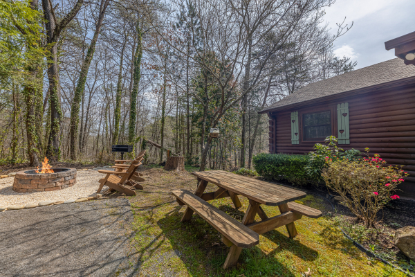 Fire pit and picnic table at Snuggle Inn, a 2 bedroom cabin rental located in Pigeon Forge