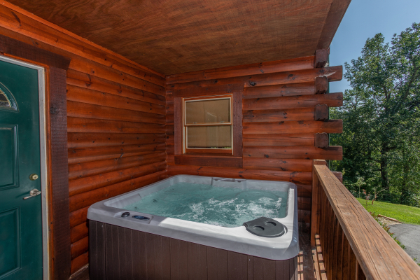 Hot tub on a covered deck at Leconte View Lodge, a 3 bedroom cabin rental located in Pigeon Forge