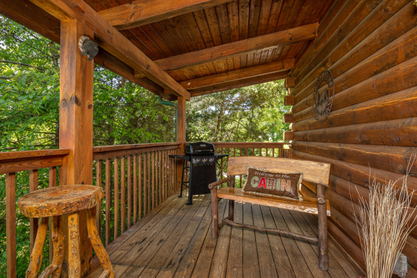 Grill and bench on covered deck at Eagle's Bluff, a 2 bedroom cabin rental located in douglas lake