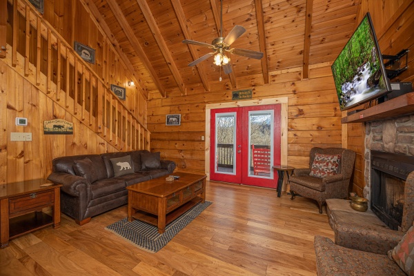 Living room with sofa, TV, fireplace, and deck access at Wonders in the Sky, a 3 bedroom cabin rental located in Gatlinburg