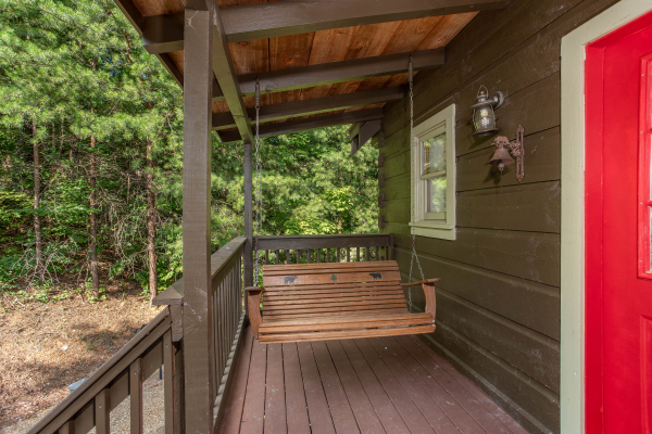 Swing on a covered porch at Wonders in the Sky, a 3 bedroom cabin rental located in Gatlinburg
