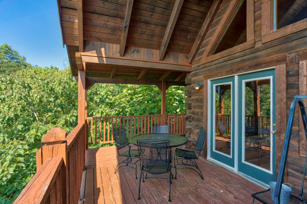 dining space for four on a covered deck at angel's majestic view a 3 bedroom cabin rental located in pigeon forge