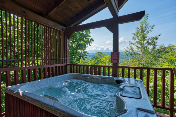 hot tub on a covered deck at angel's majestic view a 3 bedroom cabin rental located in pigeon forge