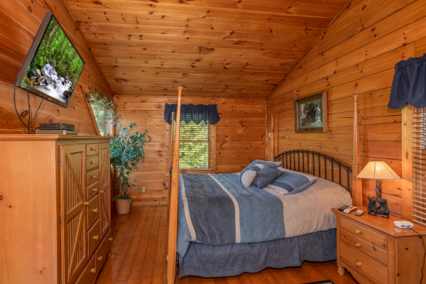 bedroom with four post bed and television at angel's majestic view a 3 bedroom cabin rental located in pigeon forge