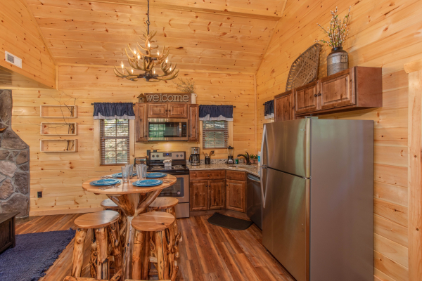 Pub style table for four and stainless appliances in a kitchen at Out on a Limb, a 1 bedroom cabin rental located in Gatlinburg