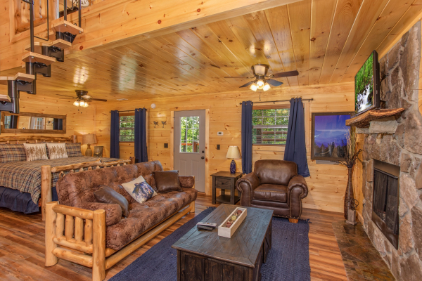 Studio-style main floor with king bed, living room with fireplace and TV at Out on a Limb, a 1 bedroom cabin rental located in Gatlinburg