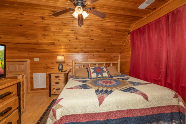 Loft bedroom with a king bed, night stand, and lamp at Cabin Life, a 2 bedroom cabin rental located in Pigeon Forge