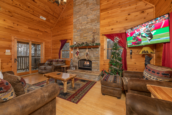 Living room with lots of seating, fireplace, and TV at Cabin Life, a 2 bedroom cabin rental located in Pigeon Forge