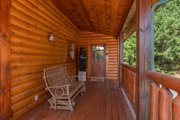 Gliding loveseat on the covered deck at Cabin Fever, a 4-bedroom cabin rental located in Pigeon Forge