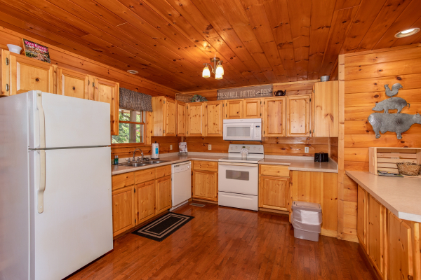 Kitchen with white appliances at Cabin Fever, a 4-bedroom cabin rental located in Pigeon Forge