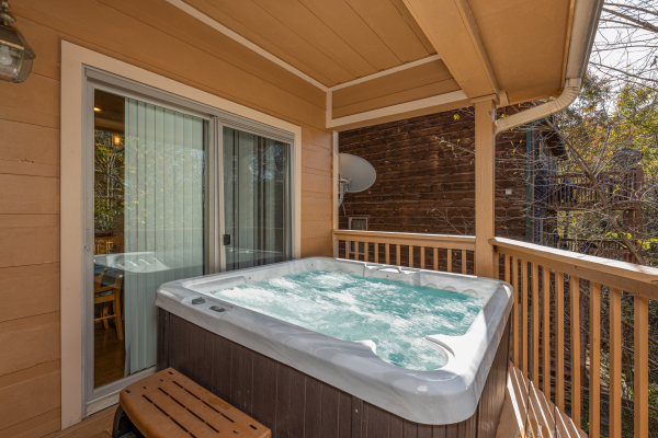 Hot tub on a covered deck at Into the Woods, a 3 bedroom cabin rental located in Pigeon Forge
