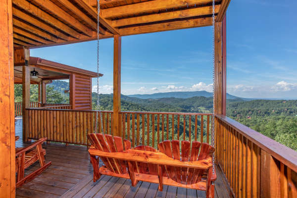 Adirondack style porch swing overlooking the views at Four Seasons Palace, a 5-bedroom cabin rental located in Pigeon Forge 