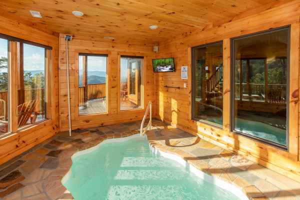 Indoor pool room with a TV at Four Seasons Palace, a 5-bedroom cabin rental located in Pigeon Forge