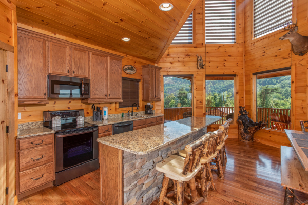 Kitchen with stainless appliances and counter seating for four at Four Seasons Palace, a 5-bedroom cabin rental located in Pigeon Forge