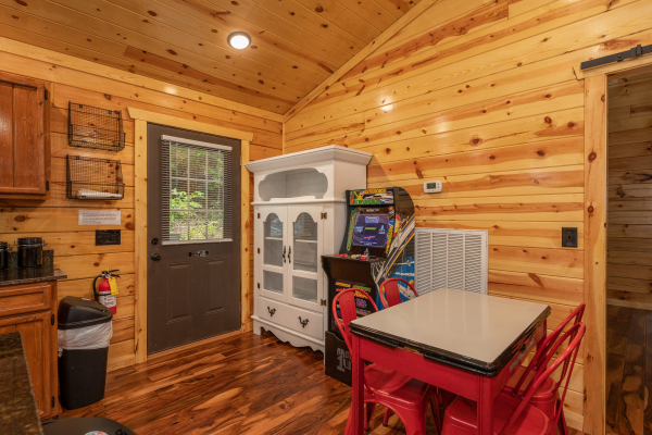 Dining space with hutch and arcade game at Paws on the Porch, a 2 bedroom cabin rental located in Gatlinburg