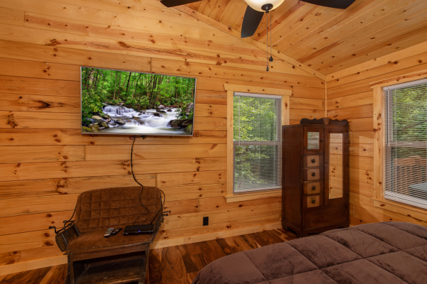TV, chair, and armoire in the bedroom at Paws on the Porch, a 2 bedroom cabin rental located in Gatlinburg