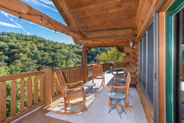 Outdoor seating with string lighting on the covered deck at Great View Lodge, a 5-bedroom cabin rental located in Pigeon Forge