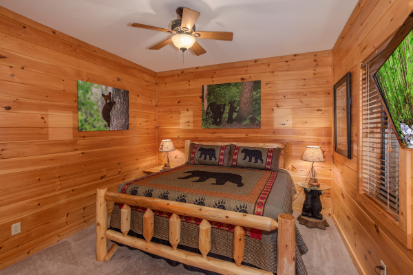 King-sized log bed and two end tables at Great View Lodge, a 5-bedroom cabin rental located in Pigeon Forge