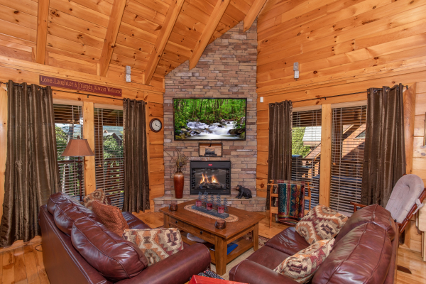 Living room stone fireplace and television at Bears Eye View, a 2-bedroom cabin rental located in Pigeon Forge