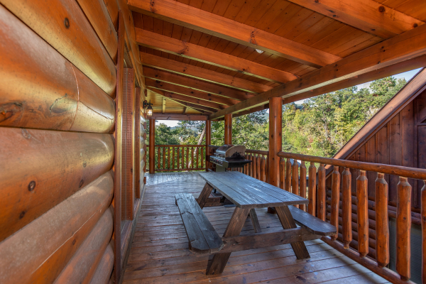Picnic table on a covered deck at Bears Eye View, a 2-bedroom cabin rental located in Pigeon Forge