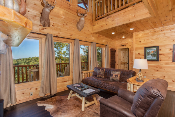 Living room with high ceiling and large windows at Panorama, a 2 bedroom cabin rental located in Pigeon Forge