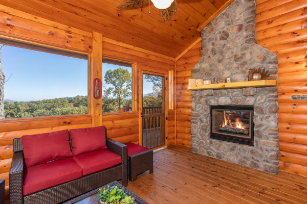 Fireplace on the screened in porch at Panorama, a 2 bedroom cabin rental located in Pigeon Forge