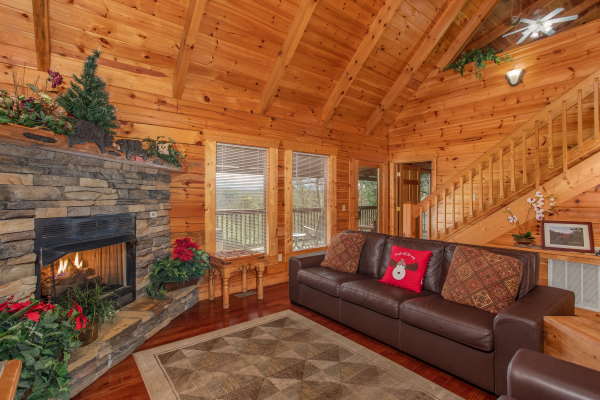 Fireplace and sofa in the vaulted living room at Enchanted Evening, a 1 bedroom Pigeon Forge cabin rental 