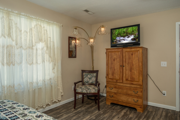 Armoire, TV, and chair in a bedroom at Peace at the River, a 3 bedroom cabin rental located in Pigeon Forge
