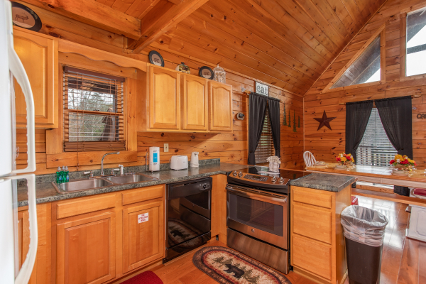 Kitchen with counter top seating and a dining space for six at Hibernation Station, a 3-bedroom cabin rental located in Pigeon Forge