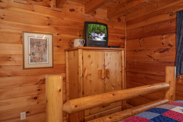 Armoire and TV in a bedroom at American Beauty, a 2 bedroom cabin rental located in Pigeon Forge