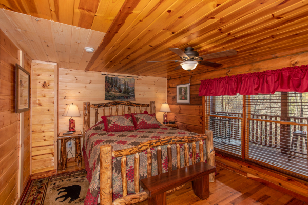 Bedroom with a log bed, night stands, and lamps at Moonshiner's Ridge, a 1-bedroom cabin rental located in Pigeon Forge