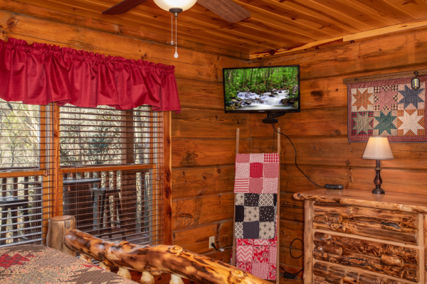 Dresser and TV in a bedroom at Moonshiner's Ridge, a 1-bedroom cabin rental located in Pigeon Forge