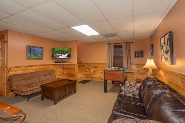 Game room with TV, foosball, and sofas at Granny D's, a 2 bedroom cabin rental located in Pigeon Forge
