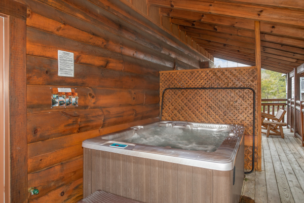 Hot tub and privacy lattice on the covered deck at Granny D's, a 2 bedroom cabin rental located in Pigeon Forge