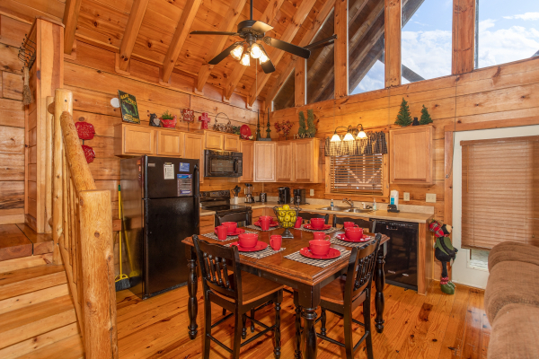 Dining space for six in the kitchen with black appliances at Granny D's, a 2 bedroom cabin rental located in Pigeon Forge