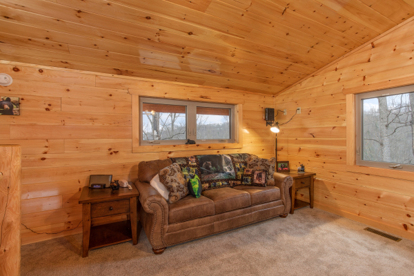 Queen sleeper sofa in the living room at Happy Bear's Hideaway, a 2 bedroom cabin rental located in Gatlinburg