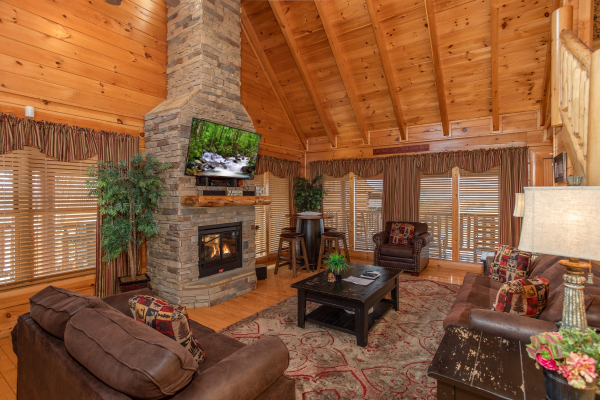 Living room with vaulted ceiling, tall fireplace, and TV at Better View, a 4 bedroom cabin rental located in Pigeon Forge