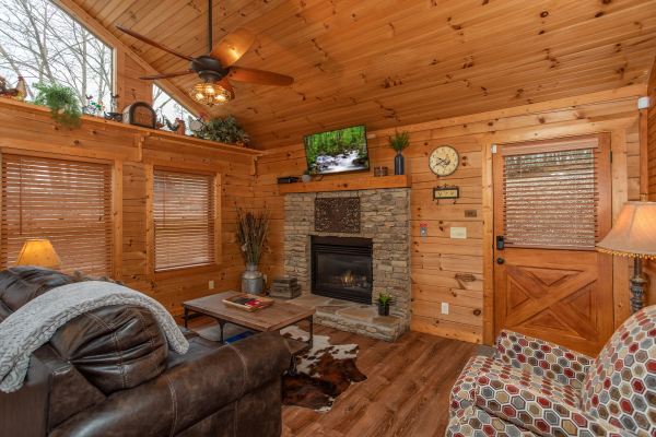 Living room with fireplace and TV at Fowl Play, a 1 bedroom cabin rental located in Pigeon Forge