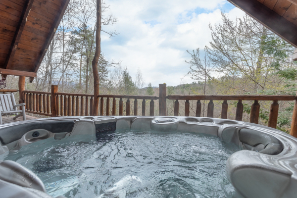 Hot tub on a covered deck with mountain views at Woodland Chalet, a 1 bedroom cabin rental located in Pigeon Forge