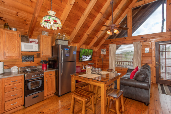 Kitchen with stainless appliances and dining space at Woodland Chalet, a 1 bedroom cabin rental located in Pigeon Forge