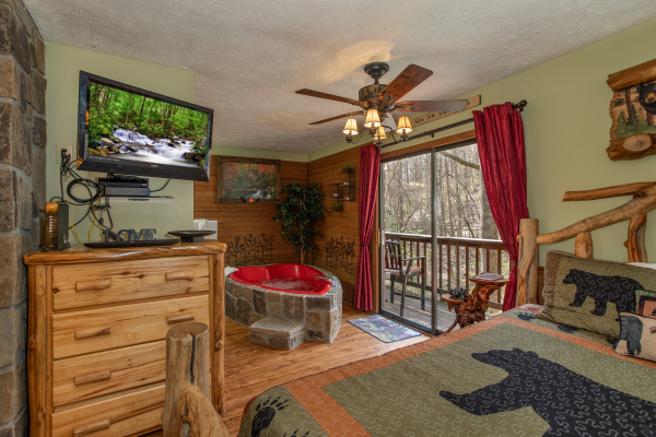 Heart shaped jacuzzi, dresser, and TV in the bedroom at Bear Mountain Hollow, a 1 bedroom cabin rental located in Pigeon Forge