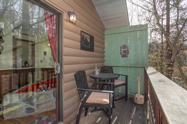 Sitting area with table and chairs on the deck at Bear Mountain Hollow, a 1 bedroom cabin rental located in Pigeon Forge