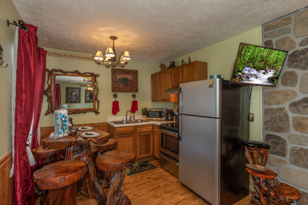 Kitchen with stainless appliances and dining space for four at Bear Mountain Hollow, a 1 bedroom cabin rental located in Pigeon Forge