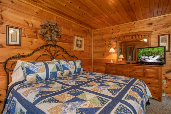 Dresser with TV and king bed in the master bedroom at Hillside Haven, a 1 bedroom cabin rental located in Pigeon Forge