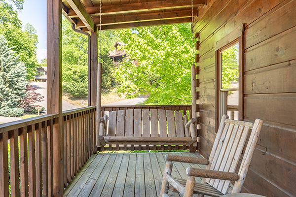Porch swing on a covered deck at Livin' Simple, a 2 bedroom cabin rental located in Pigeon Forge